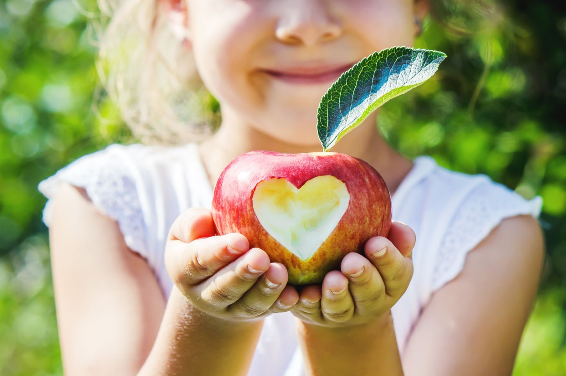 child-with-apple-selective-focus-garden